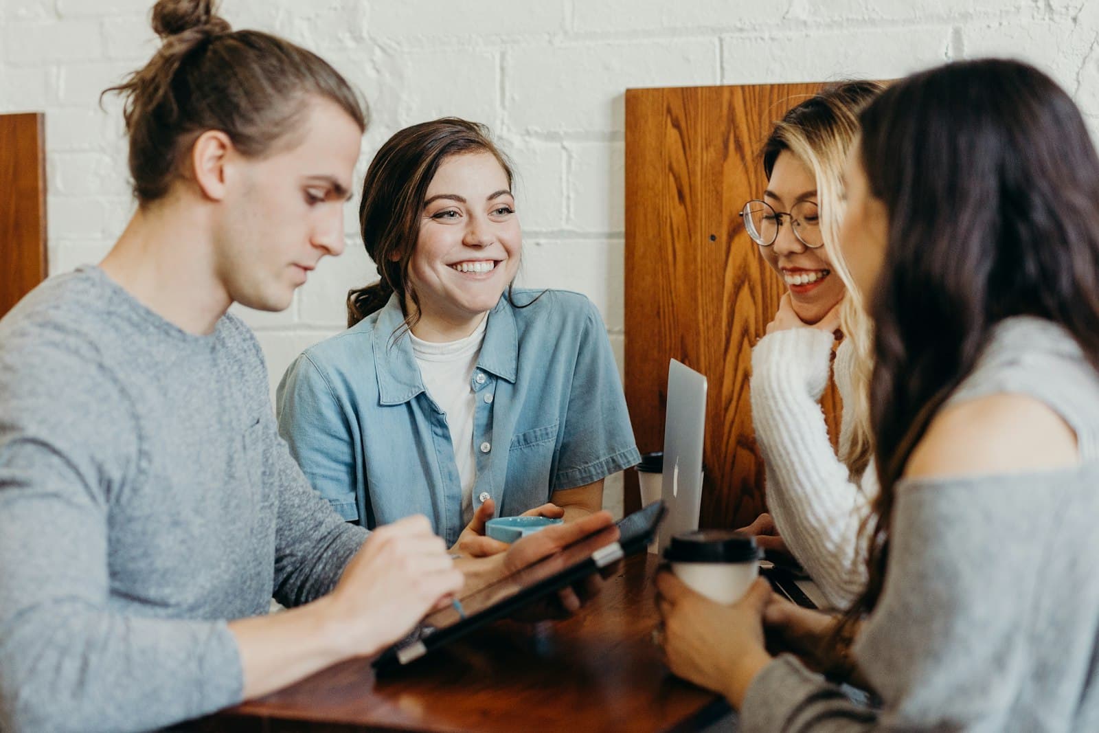Photo: Unsplash A small team around a table, looking at a laptop together