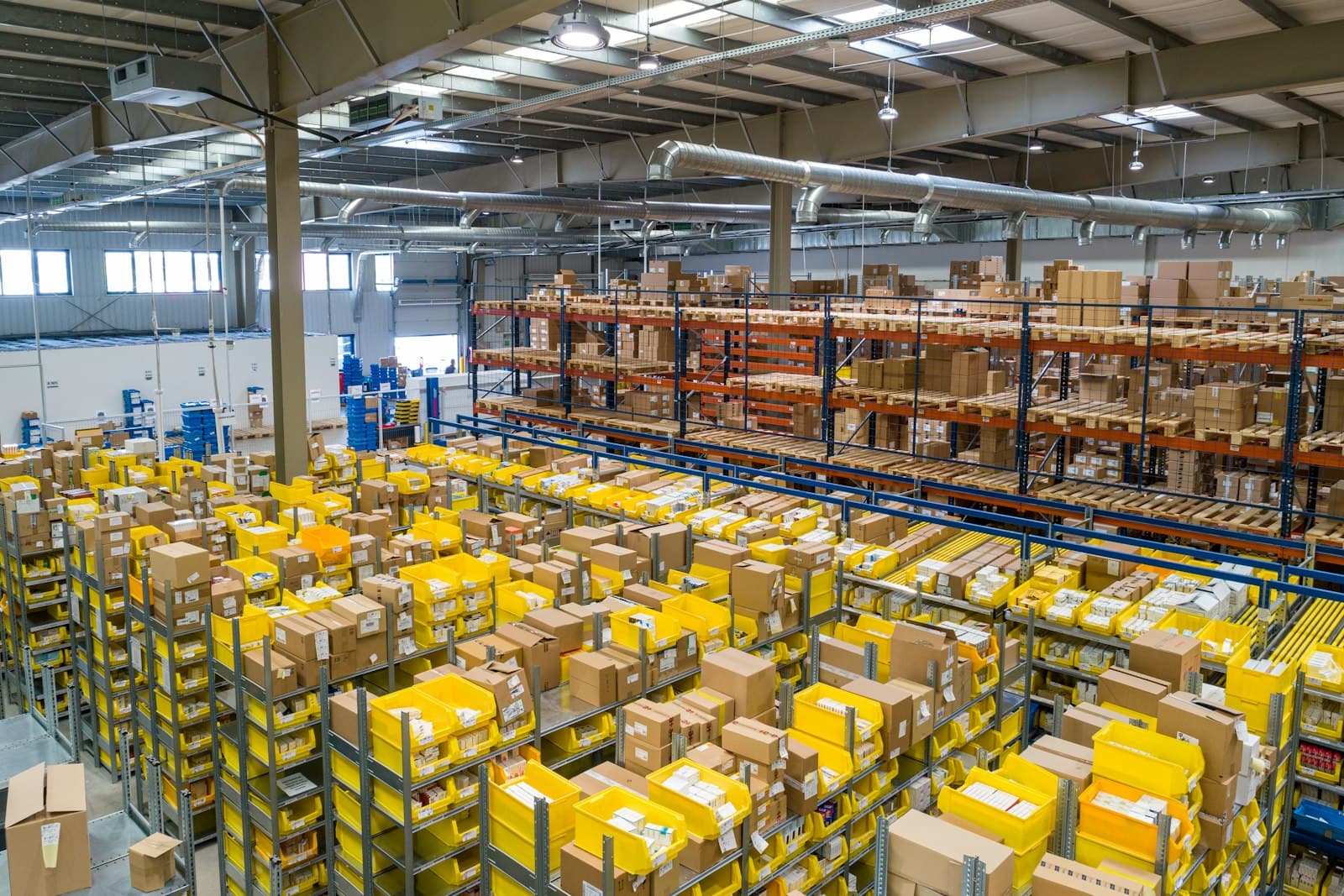 Photo: Unsplash A large warehouse with racks of stock and yellow picking totes