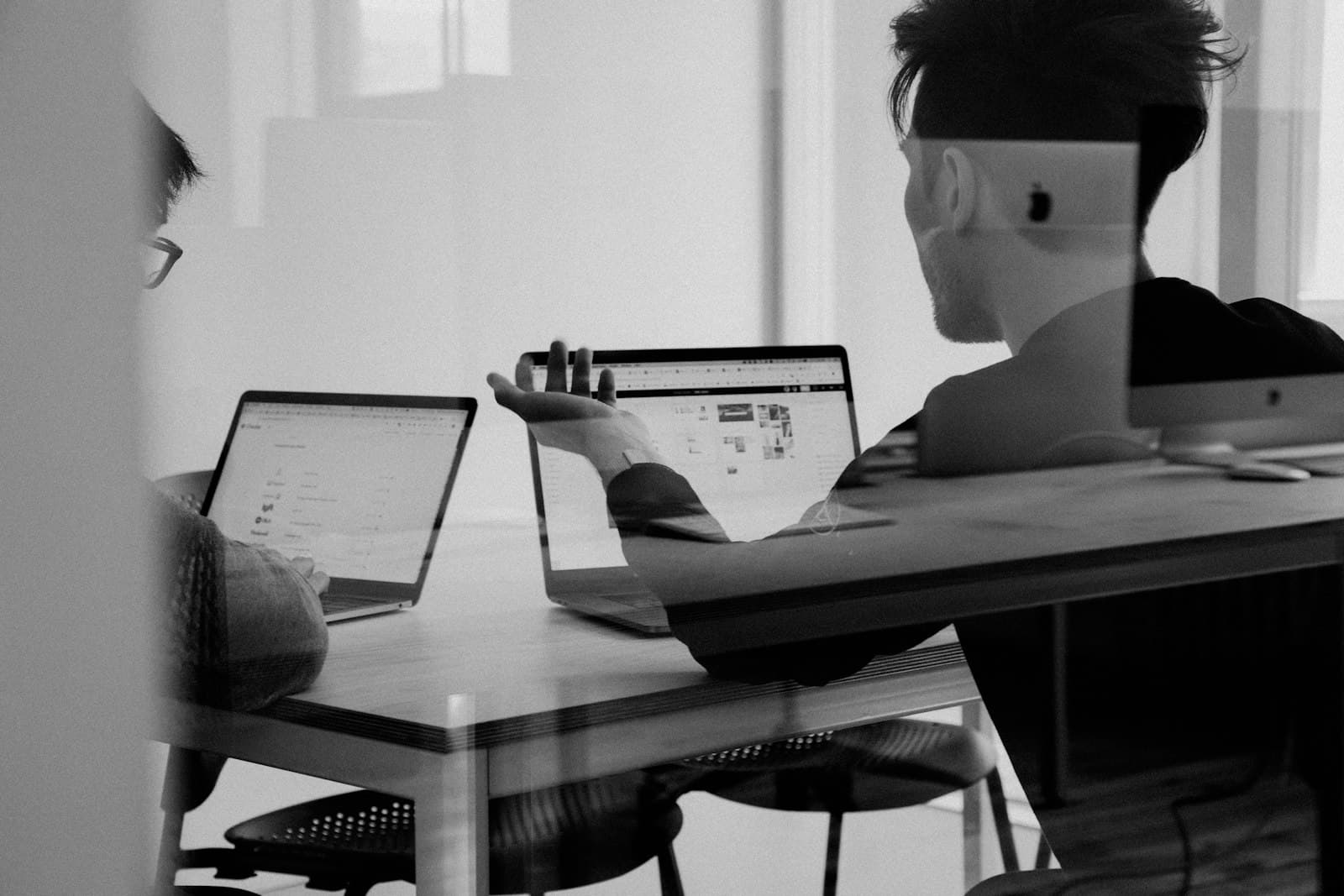 Photo: Alvaro Reyes, Unsplash A person at a laptop in front of a whiteboard, in black and white