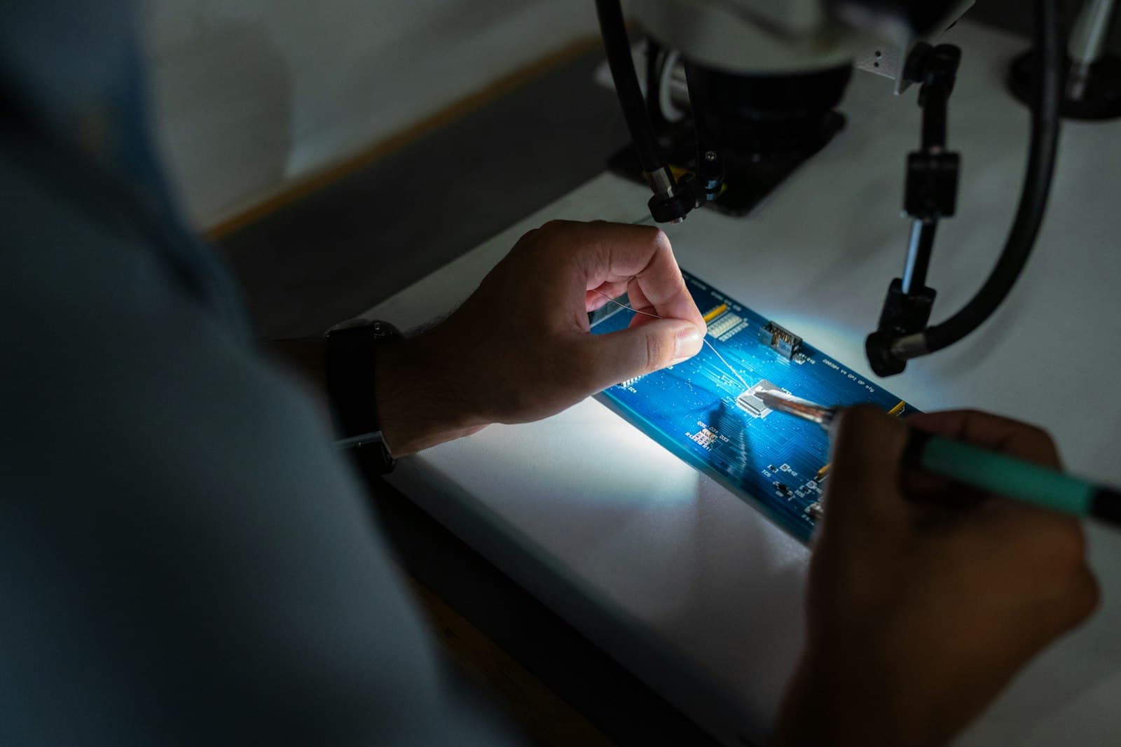 Photo: ThisisEngineering RAEng, Unsplash A hand using a stylus on a tablet in a dimly lit lab